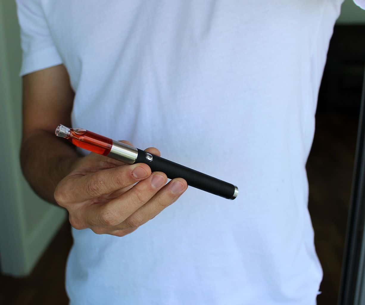 Man holding THC wax vaporizer pen